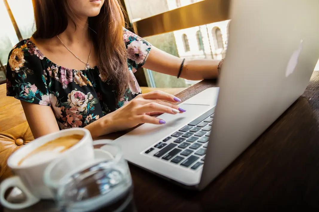 woman working on a laptop at a coffee shop