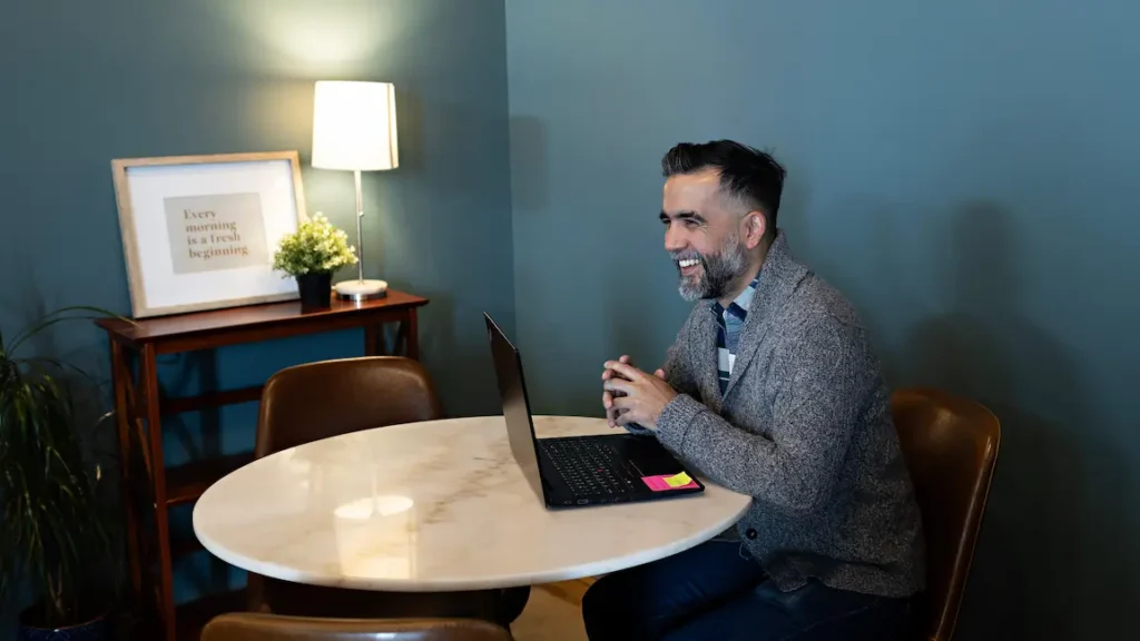 man sitting at a table with a laptop